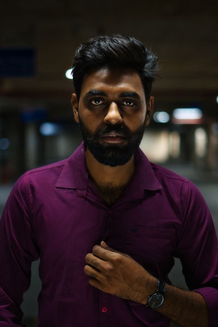 Indoor portrait of a bearded man in a dimly lit setting in Chandigarh.